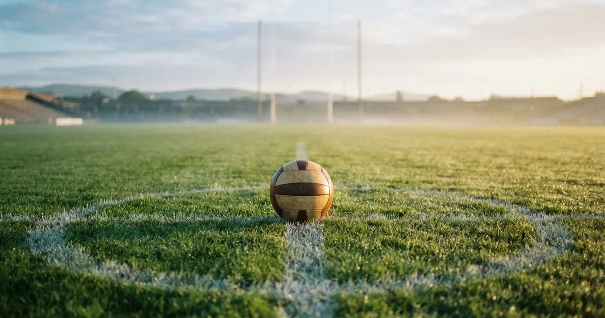 A ball on the centre spot of a grass pitch in morning light