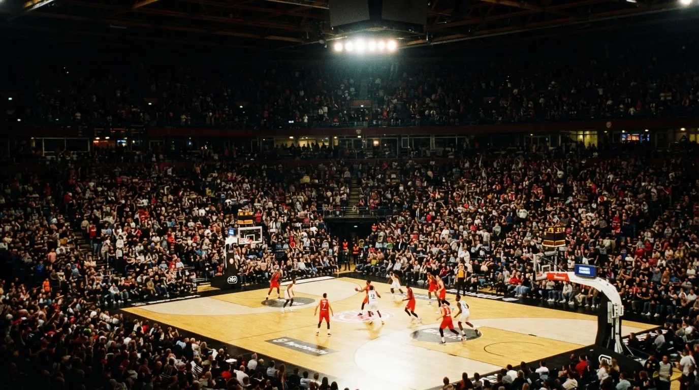 A packed sports hall under floodlights photographed from a long way off